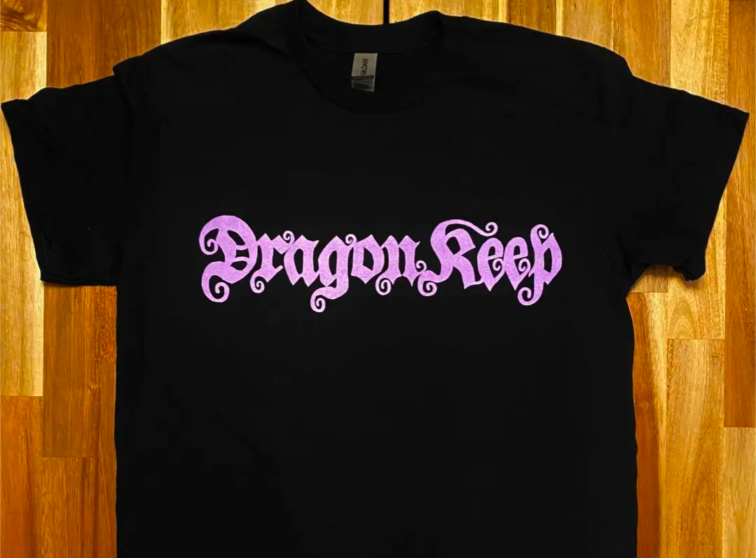 Black tee shirt with purple logo printed in front which says Dragon Keep